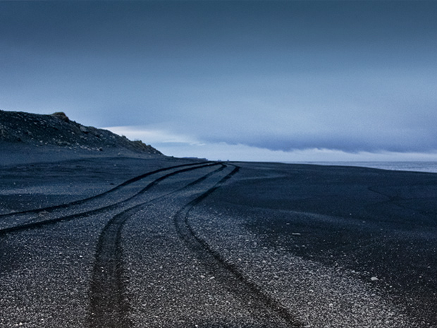 Автомобильные следы на черном песке. Берег моря в районе Reynisfjara